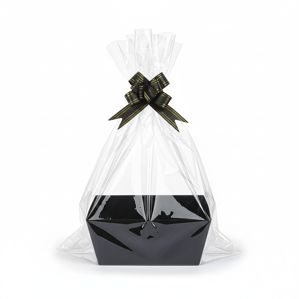 Giftplug decorative black gift basket with clear cellophane wrapping and a black and gold bow on a white background.