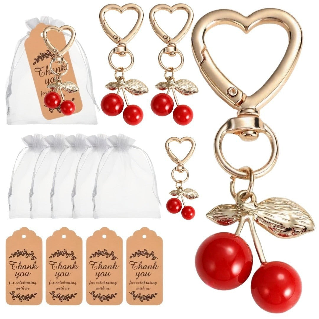 Giftplug cherry heart-shaped keychains with gold clasps, organza gift bags, and thank you tags for party favors.